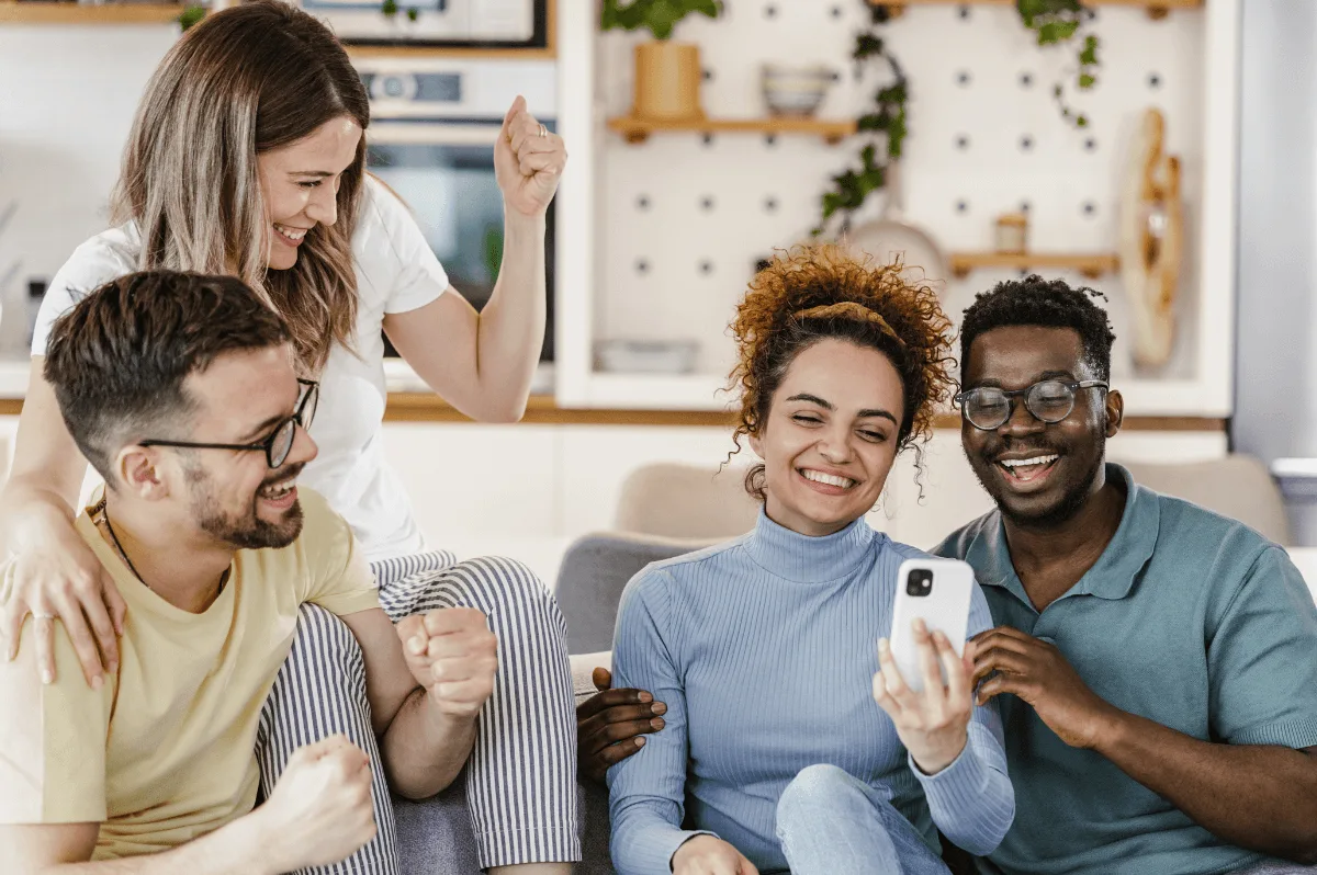Friends celebrating together while sharing a smartphone